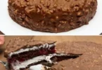 Torta lampone con ripieno di lampone e crema bianca decorata.