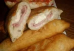 Calzoni fritti ripieni di formaggio e carne sul piatto