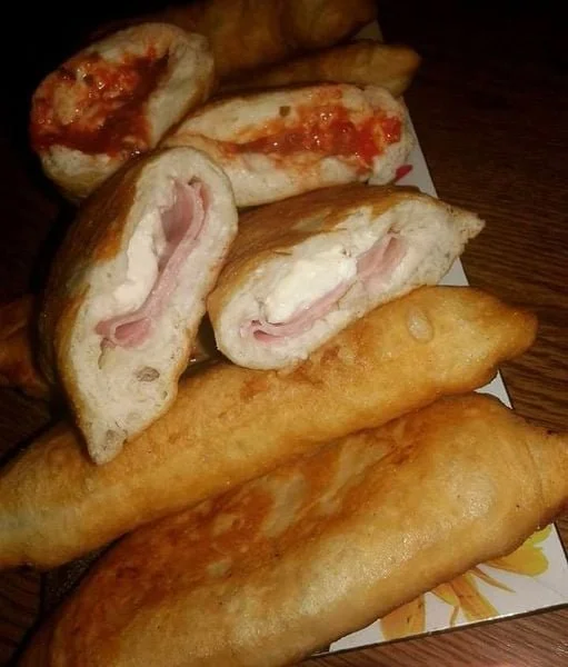 Calzoni fritti ripieni di formaggio e carne sul piatto