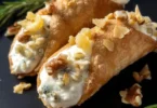 Cannoli di pane ripieni di gorgonzola e noci su un piatto elegante.