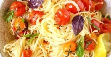 Piatto di Capellini al Pomodoro servito con basilico fresco.