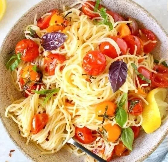 Piatto di Capellini al Pomodoro servito con basilico fresco.