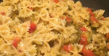 Farfalle zucchine e pomodorini servite in un piatto colorato