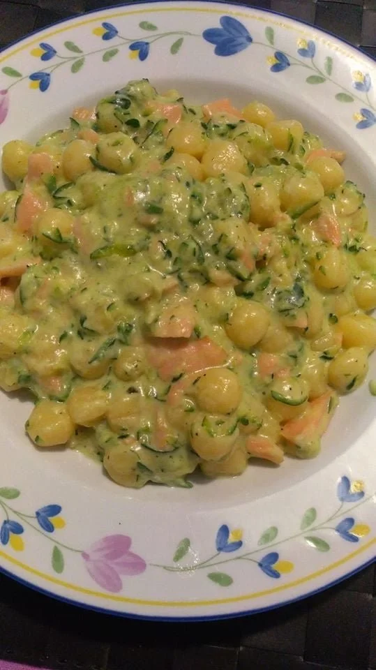 Piatto di gnocchetti zucchine e salmone affumicato con decorazioni fresche