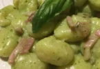 Gnocchi di patate con crema di Speck Robiola e pesto serviti in un piatto