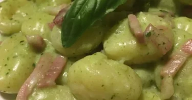 Gnocchi di patate con crema di Speck Robiola e pesto serviti in un piatto