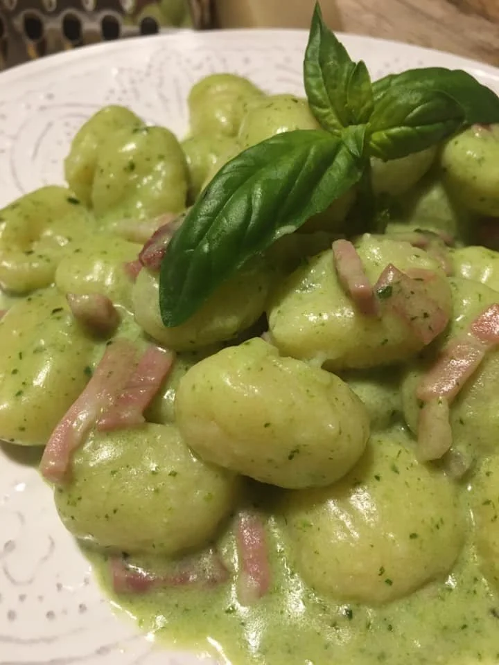 Gnocchi di patate con crema di Speck Robiola e pesto serviti in un piatto