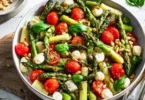 Insalata di asparagi verdi con pomodori e mozzarella su un piatto decorativo