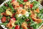 Insalata di salmone affumicato e rucola servita in un piatto colorato