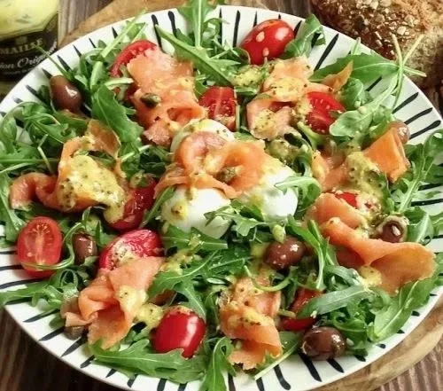 Insalata di salmone affumicato e rucola servita in un piatto colorato