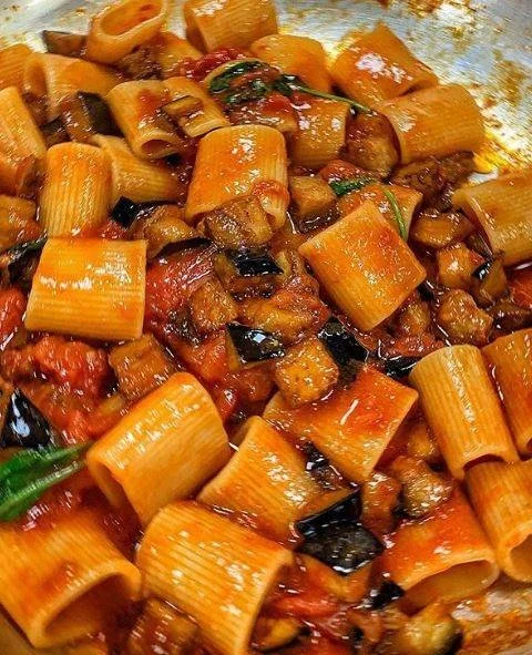 Piatto di Mezze Maniche alla Norma con melanzane e pomodoro fresco