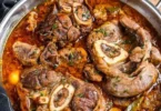 Piatto di ossobuco cotto lentamente con gremolata e contorni di stagione.