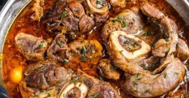 Piatto di ossobuco cotto lentamente con gremolata e contorni di stagione.