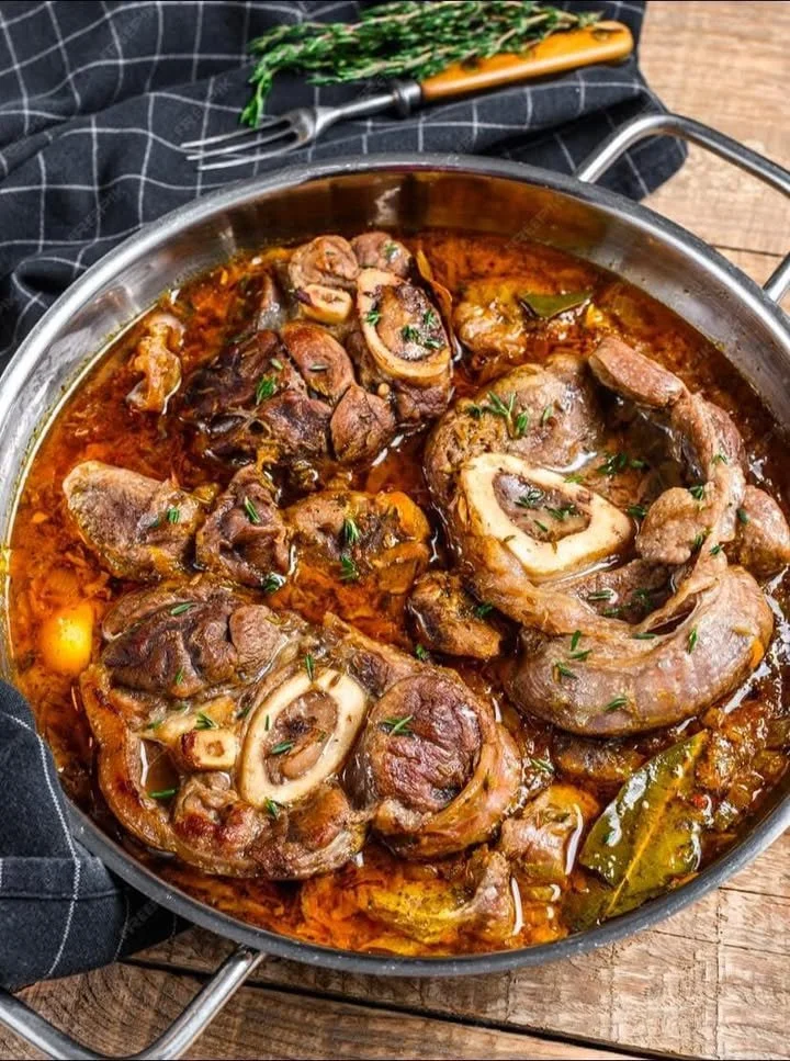 Piatto di ossobuco cotto lentamente con gremolata e contorni di stagione.