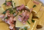 Paccheri con crema di patate e pancetta serviti in un piatto