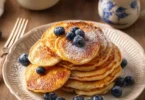 Pancake con mele grattugiate serviti con sciroppo d'acero.
