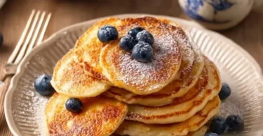 Pancake con mele grattugiate serviti con sciroppo d'acero.