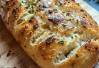 Fetta di pane all'aglio fumante servita su un piatto elegante.