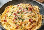 Pasta all'uovo con pancetta e parmigiano servita in un piatto delizioso