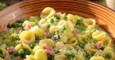 Pasta piselli e patate servita in un piatto colorato con ingredienti freschi.