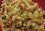 Pasta risottata con zucchina, patata, cipolla e pancetta affumicata in un piatto gourmet.