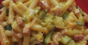 Pasta risottata con zucchina, patata, cipolla e pancetta affumicata in un piatto gourmet.