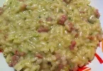 Risotto con crema di zucchine e salsiccia, piatto delizioso e cremoso.