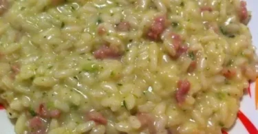 Risotto con crema di zucchine e salsiccia, piatto delizioso e cremoso.