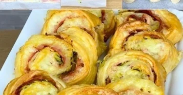 Rotolo di pasta sfoglia farcito con prosciutto e zucchine, pronto da servire.