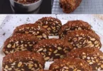 Un fetta di salame di cioccolato su un piatto con decorazioni di cacao.