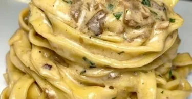 Tagliatelle con crema di parmigiano e funghi porcini in un piatto gourmet