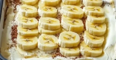 Torta di banana senza cottura decorata con fette di banana e panna