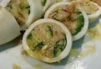 Tubi di totano ripieni con gamberetti e zucchine preparati in un piatto gourmet.
