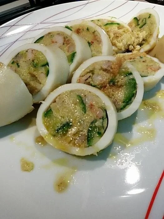 Tubi di totano ripieni con gamberetti e zucchine preparati in un piatto gourmet.