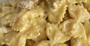 Piatto di farfalle salsiccia panna e zafferano con decorazioni gourmet