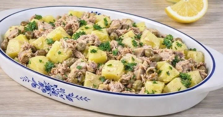 Insalata di tonno e patate servita in un piatto bianco