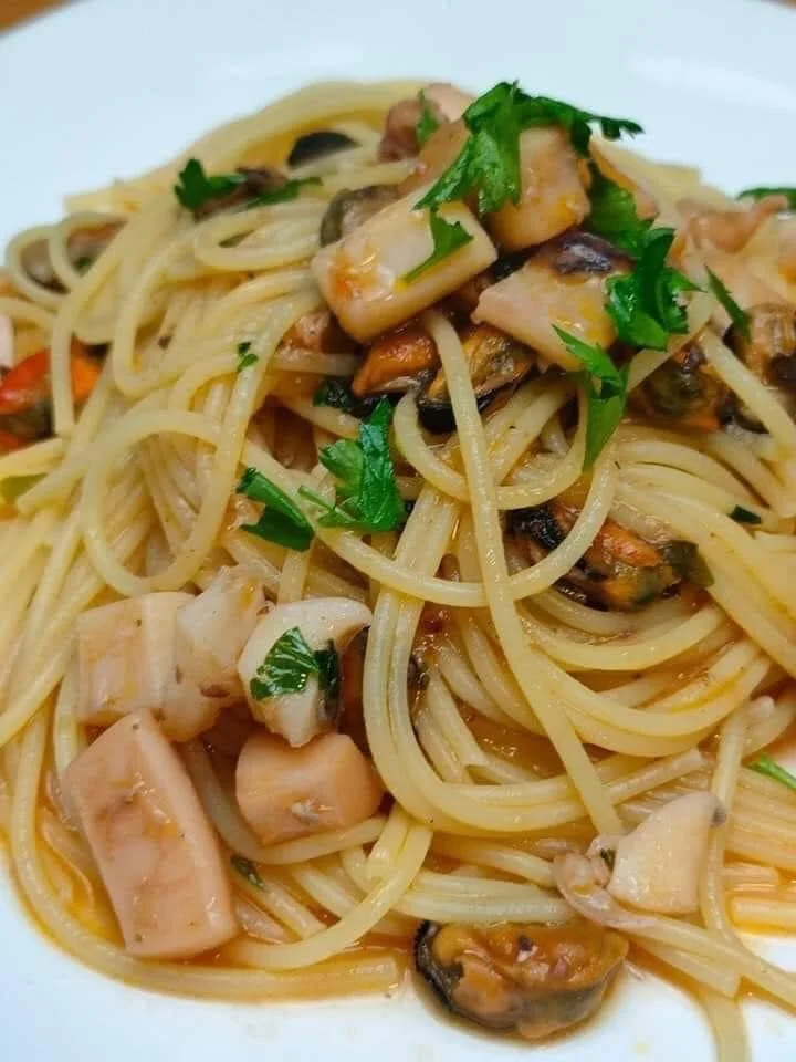 Piatto di spaghetti con calamari e cozze fresche